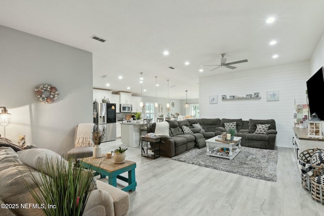 living room featuring ceiling fan and light wood-type flooring