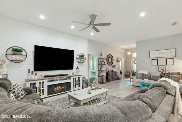 living room featuring light hardwood / wood-style floors and ceiling fan