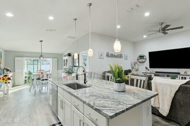 kitchen with a kitchen island with sink, ceiling fan, sink, decorative light fixtures, and white cabinets