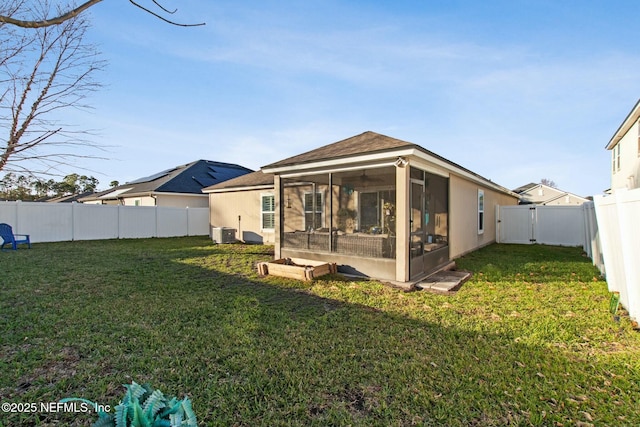 rear view of property with central air condition unit, a lawn, and a sunroom