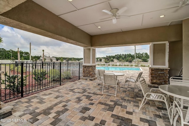 view of patio with ceiling fan and a community pool