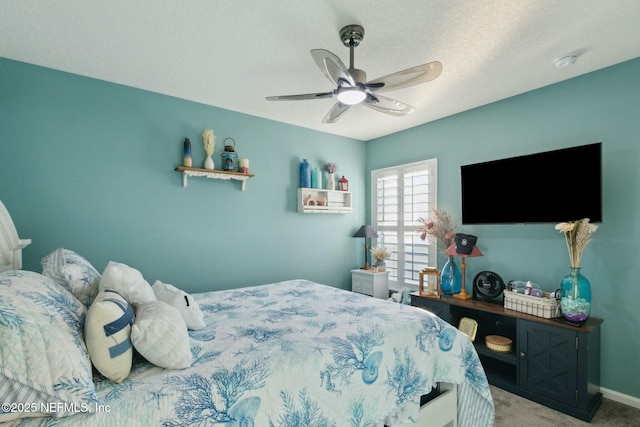 bedroom featuring carpet flooring, ceiling fan, and a textured ceiling