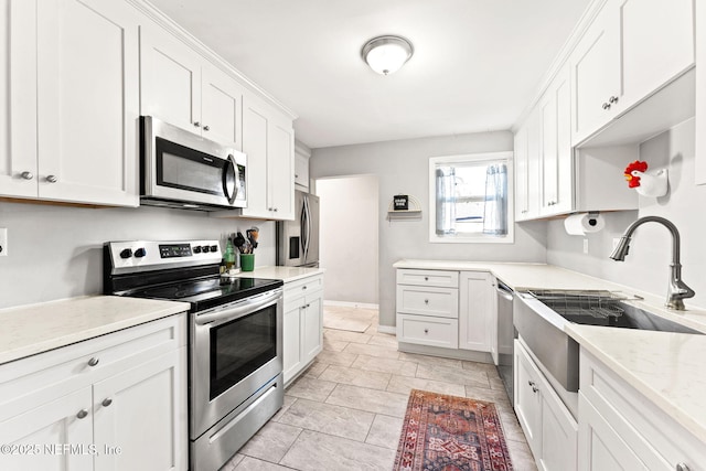 kitchen featuring light stone counters, sink, white cabinets, and stainless steel appliances