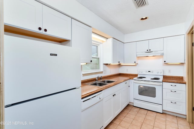 kitchen featuring white cabinetry, sink, a textured ceiling, white appliances, and light tile patterned floors