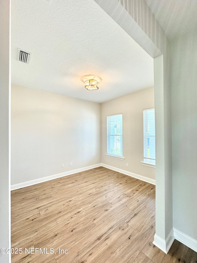 44 Vega Ct, Saint Augustine, FL 32095 - empty room with visible vents, a textured ceiling, baseboards, and wood finished floors