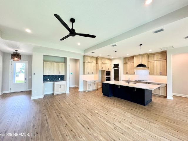 44 Vega Ct, Saint Augustine, FL 32095 - kitchen featuring visible vents, a ceiling fan, a large island, tasteful backsplash, and a sink