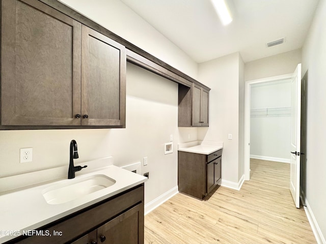 44 Vega Ct, Saint Augustine, FL 32095 - washroom featuring cabinet space, a sink, hookup for a washing machine, light wood-style flooring, and visible vents