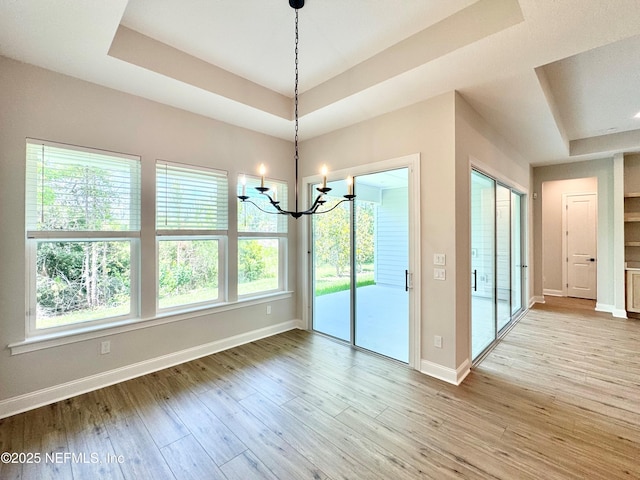 44 Vega Ct, Saint Augustine, FL 32095 - unfurnished dining area featuring baseboards, a wealth of natural light, a tray ceiling, and a notable chandelier