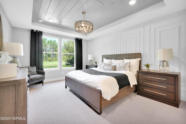 bedroom with a raised ceiling, light colored carpet, wood ceiling, and a notable chandelier