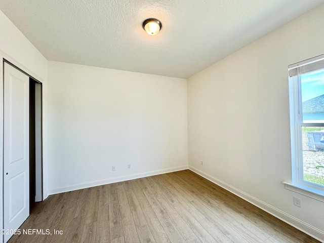 269 Pasarela Dr, Saint Augustine, FL 32095 - unfurnished bedroom featuring baseboards, a textured ceiling, wood finished floors, and a closet