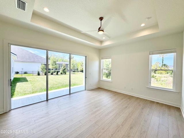 269 Pasarela Dr, Saint Augustine, FL 32095 - unfurnished room featuring a ceiling fan, baseboards, wood finished floors, a tray ceiling, and visible vents