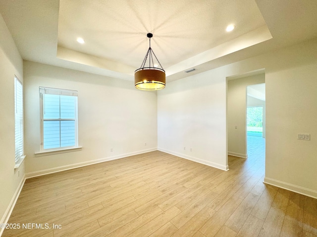 269 Pasarela Dr, Saint Augustine, FL 32095 - unfurnished room with a tray ceiling, visible vents, baseboards, and light wood-style floors