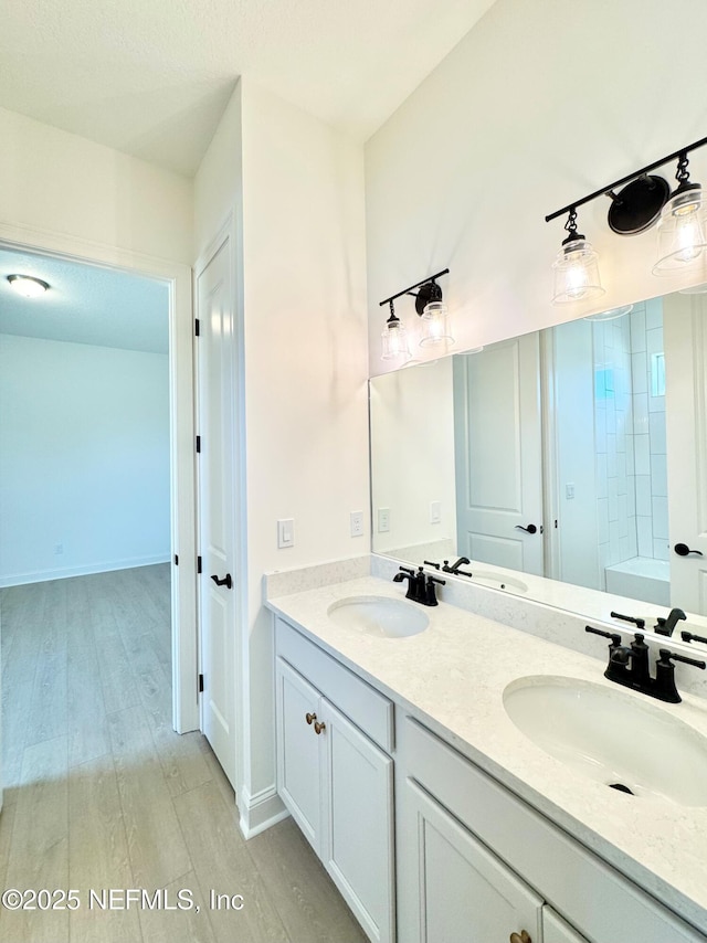 269 Pasarela Dr, Saint Augustine, FL 32095 - full bathroom with double vanity, a washtub, a sink, and wood finished floors