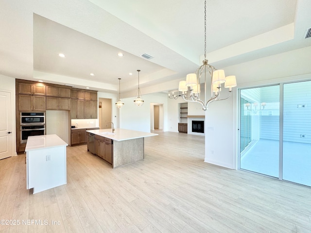 269 Pasarela Dr, Saint Augustine, FL 32095 - kitchen featuring open floor plan, an island with sink, a tray ceiling, and light countertops