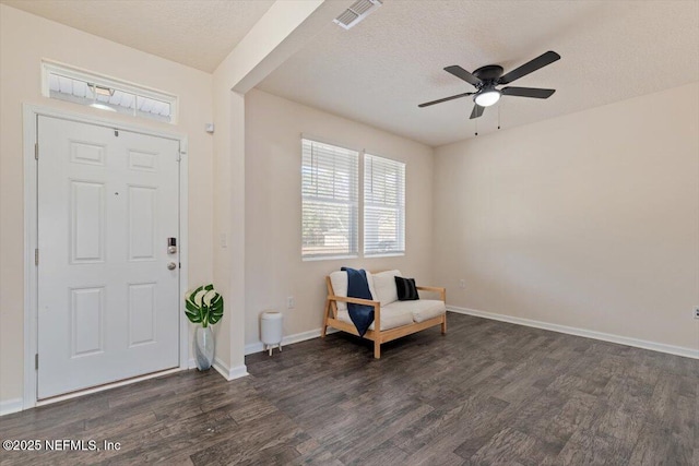 foyer featuring ceiling fan, dark hardwood / wood-style flooring, and a textured ceiling