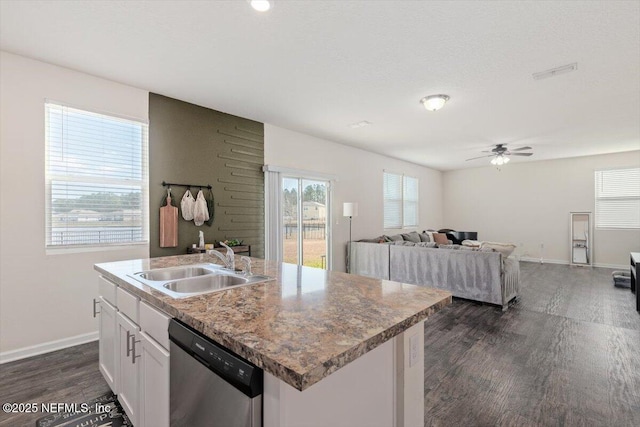 kitchen with stainless steel dishwasher, ceiling fan, sink, a center island with sink, and white cabinetry