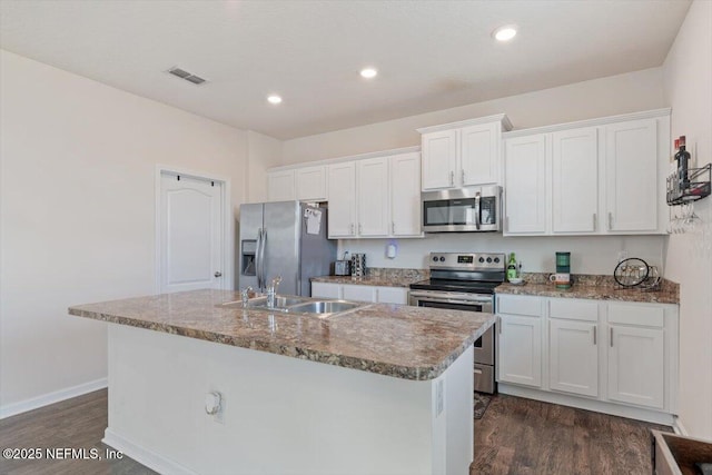 kitchen featuring white cabinets, appliances with stainless steel finishes, a center island with sink, and sink