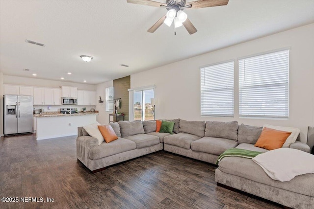 living room featuring dark hardwood / wood-style floors and ceiling fan