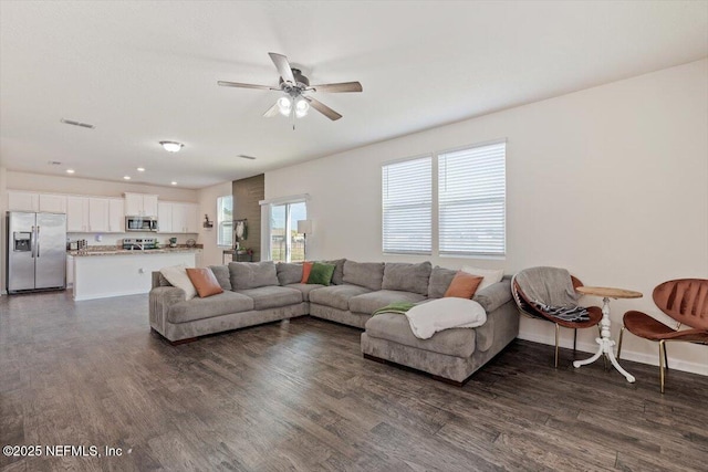 living room with ceiling fan and dark wood-type flooring