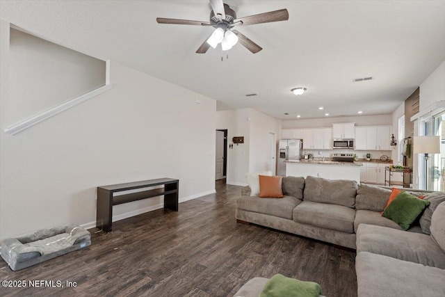 living room featuring ceiling fan and dark hardwood / wood-style floors