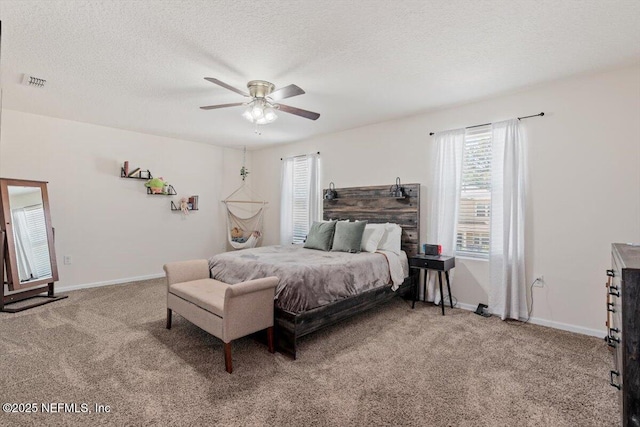 bedroom with ceiling fan, carpet floors, and a textured ceiling