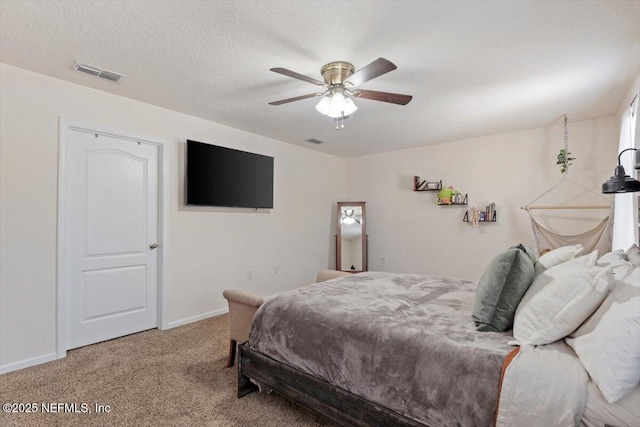 carpeted bedroom with ceiling fan and a textured ceiling