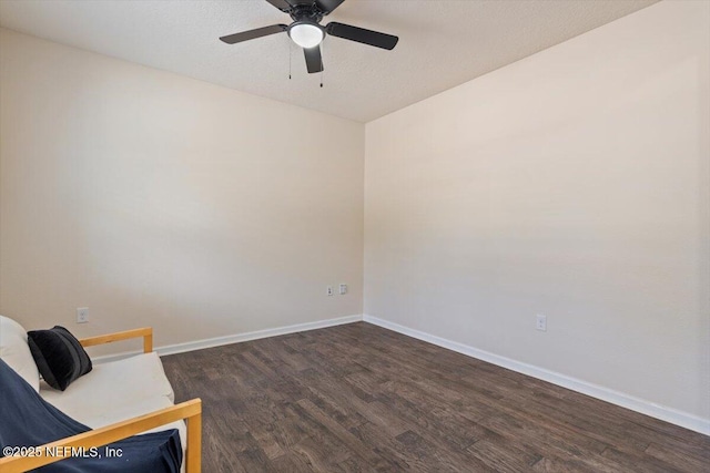 unfurnished room featuring ceiling fan and dark wood-type flooring