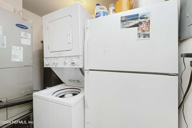 laundry area featuring stacked washer and dryer and a textured ceiling