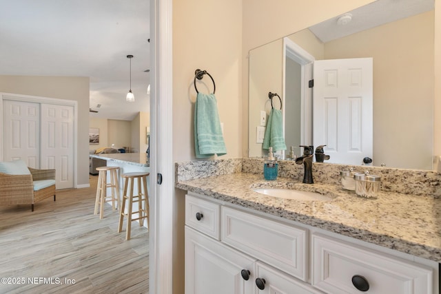 bathroom with hardwood / wood-style floors, vanity, and vaulted ceiling