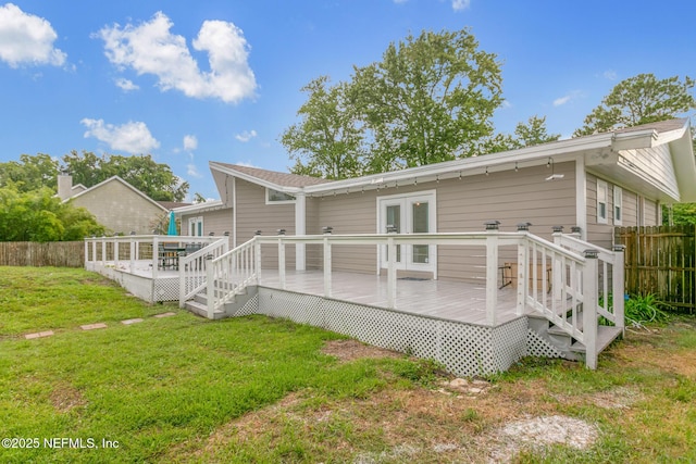 rear view of house with a lawn, french doors, and a deck