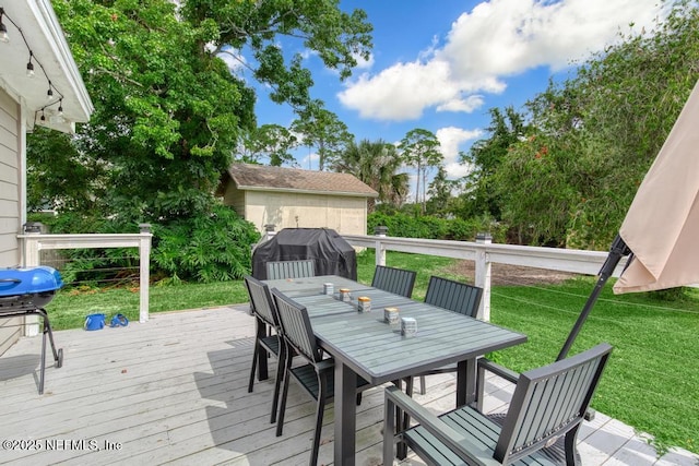 wooden deck with a yard and a grill