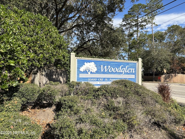 community / neighborhood sign with fence