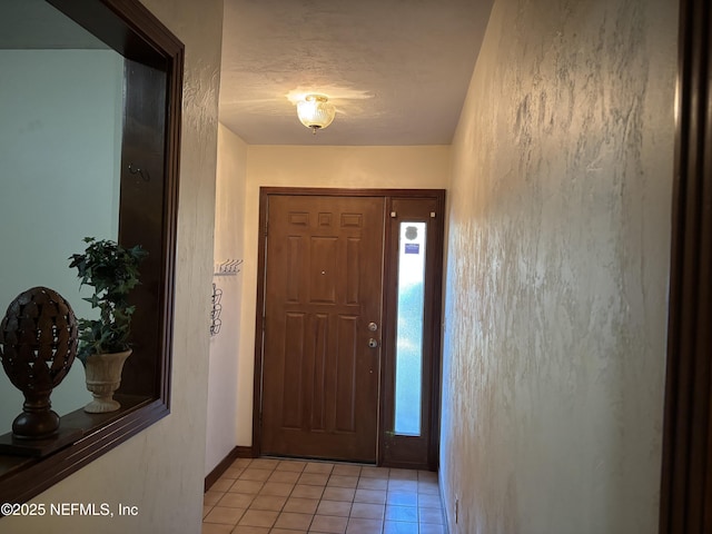 entryway with light tile patterned floors and baseboards