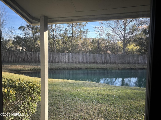 view of yard with a water view and fence