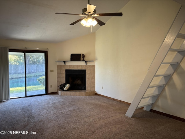 unfurnished living room with a ceiling fan, carpet, baseboards, lofted ceiling, and a tile fireplace