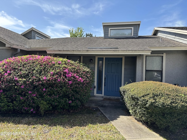 doorway to property featuring a shingled roof