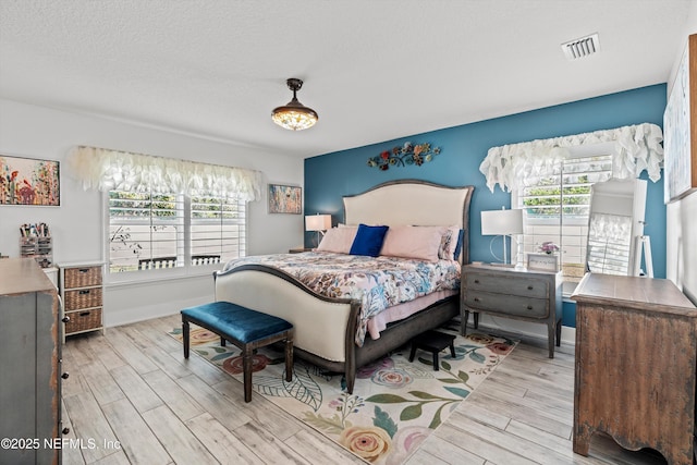 bedroom with light wood-type flooring and multiple windows