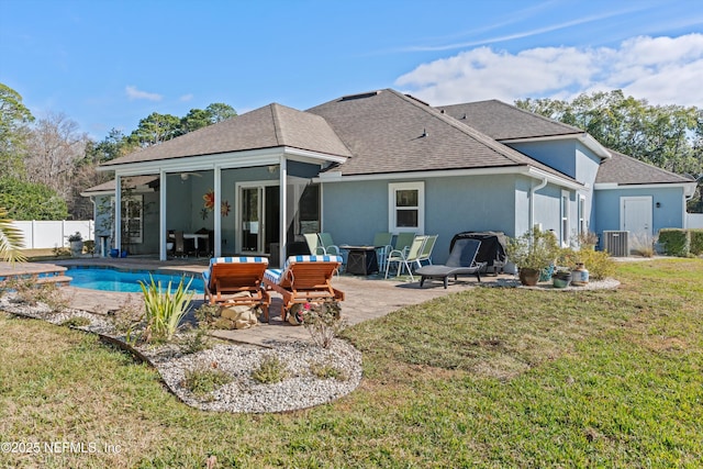 back of house with a sunroom, a yard, cooling unit, a fenced in pool, and a patio