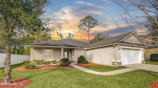 ranch-style house featuring a garage and a yard