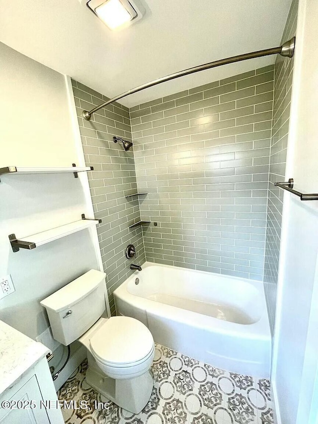 bathroom with tile patterned flooring, toilet, and tiled shower / bath