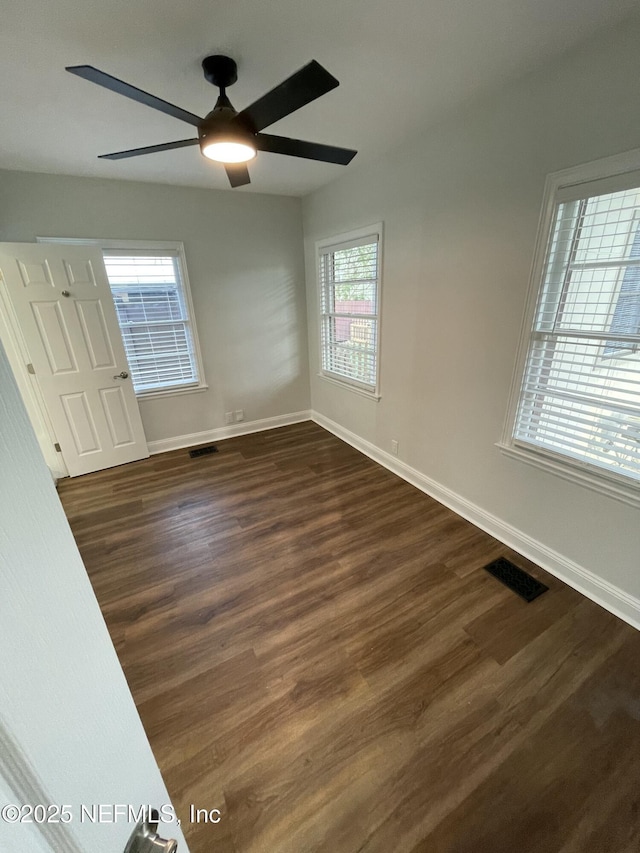 spare room featuring ceiling fan and dark wood-type flooring