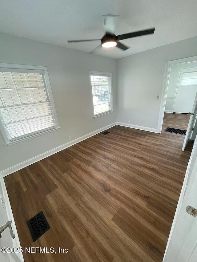 unfurnished room featuring ceiling fan and dark wood-type flooring