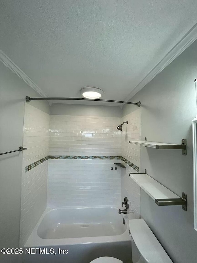 bathroom with toilet, a textured ceiling, tiled shower / bath combo, and crown molding