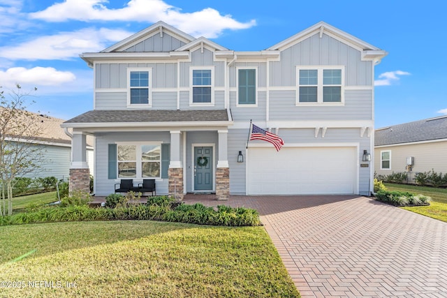 craftsman house featuring a garage, covered porch, and a front lawn