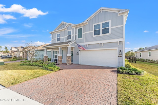 craftsman house featuring a porch, a front lawn, and a garage