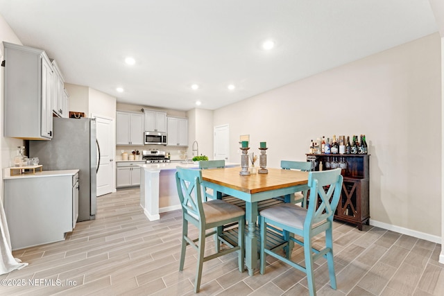 dining space featuring sink and light hardwood / wood-style floors