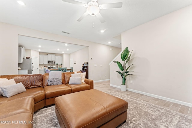 living room featuring ceiling fan and light wood-type flooring