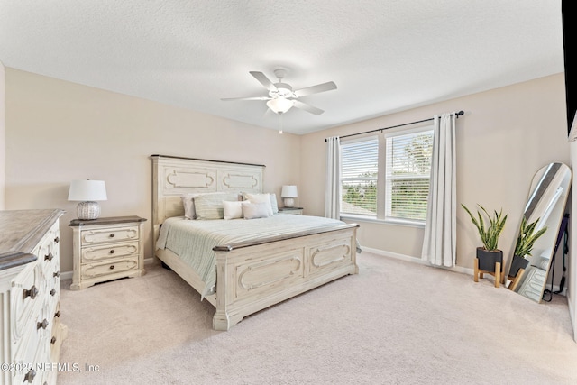 bedroom with light carpet, ceiling fan, and a textured ceiling