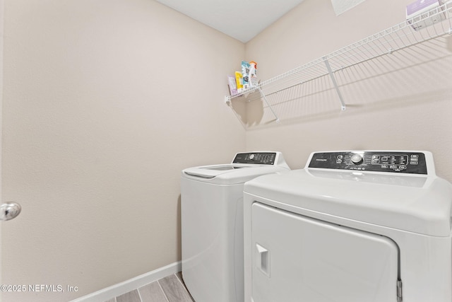 clothes washing area with hardwood / wood-style floors and separate washer and dryer