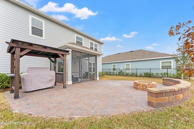 back of property featuring a patio, a fire pit, and a sunroom